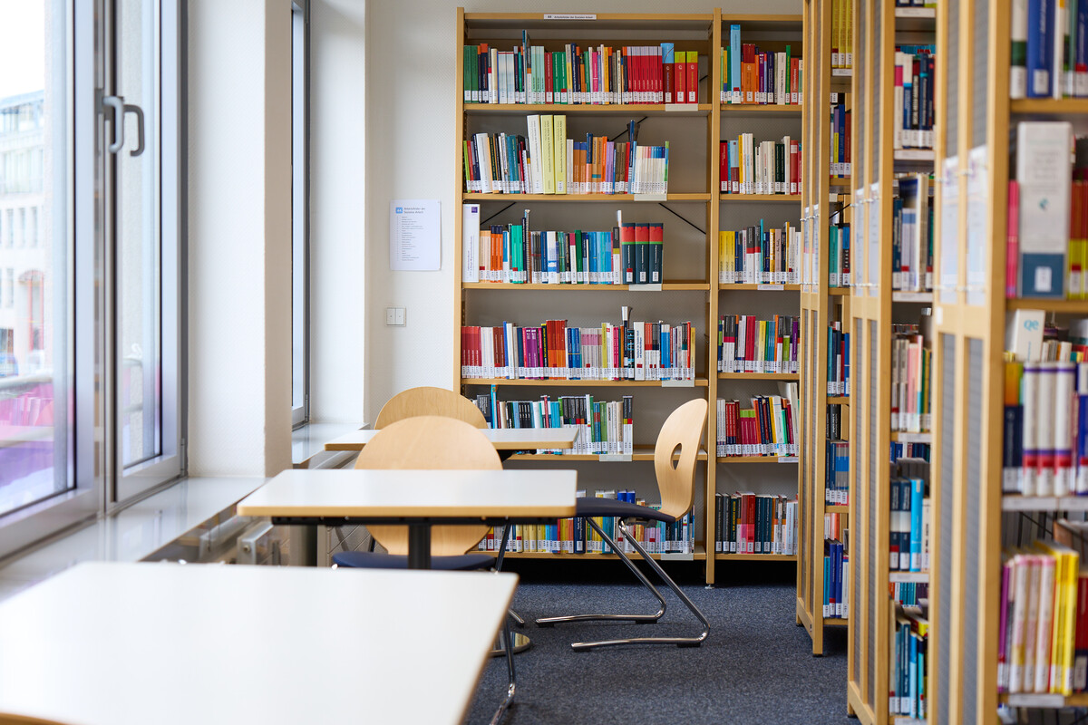 Einige leere Tische und Stühle in einer Bibliothek