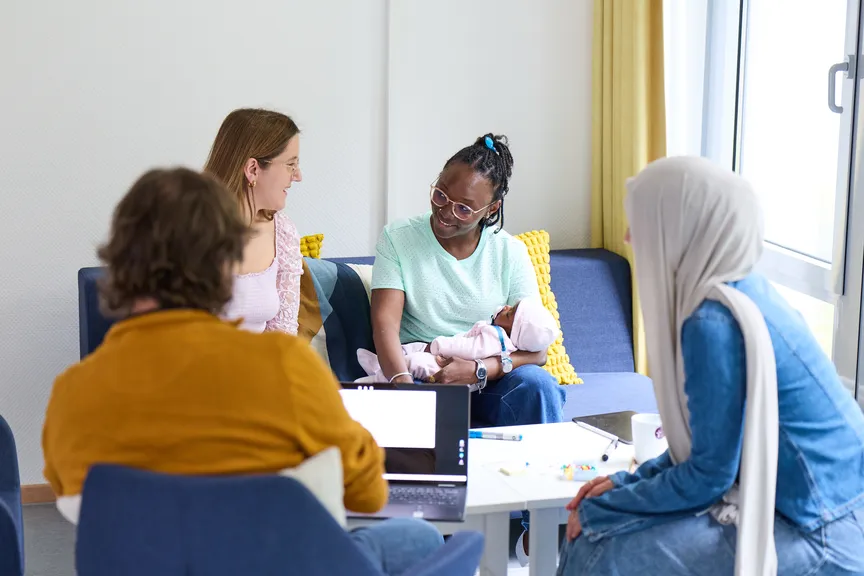 Einige Studierende sitzen in einer Sitzgruppe und unterhalten sich