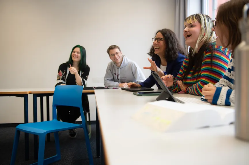 Eine fröhliche Gruppe Studierender in einem Seminar