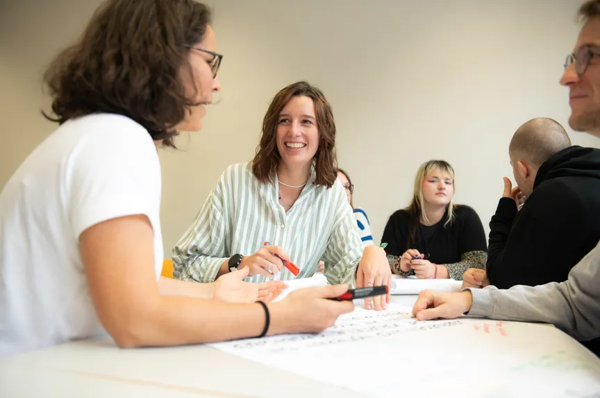 Eine fröhliche Gruppe Studierender in einem Seminar