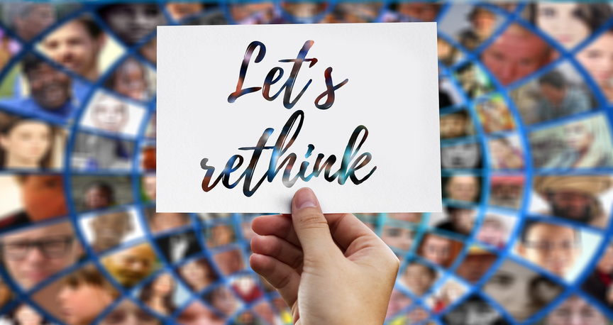 Eine Hand hält ein Blatt Papier mit dem Aufdruck "Let's rethink"