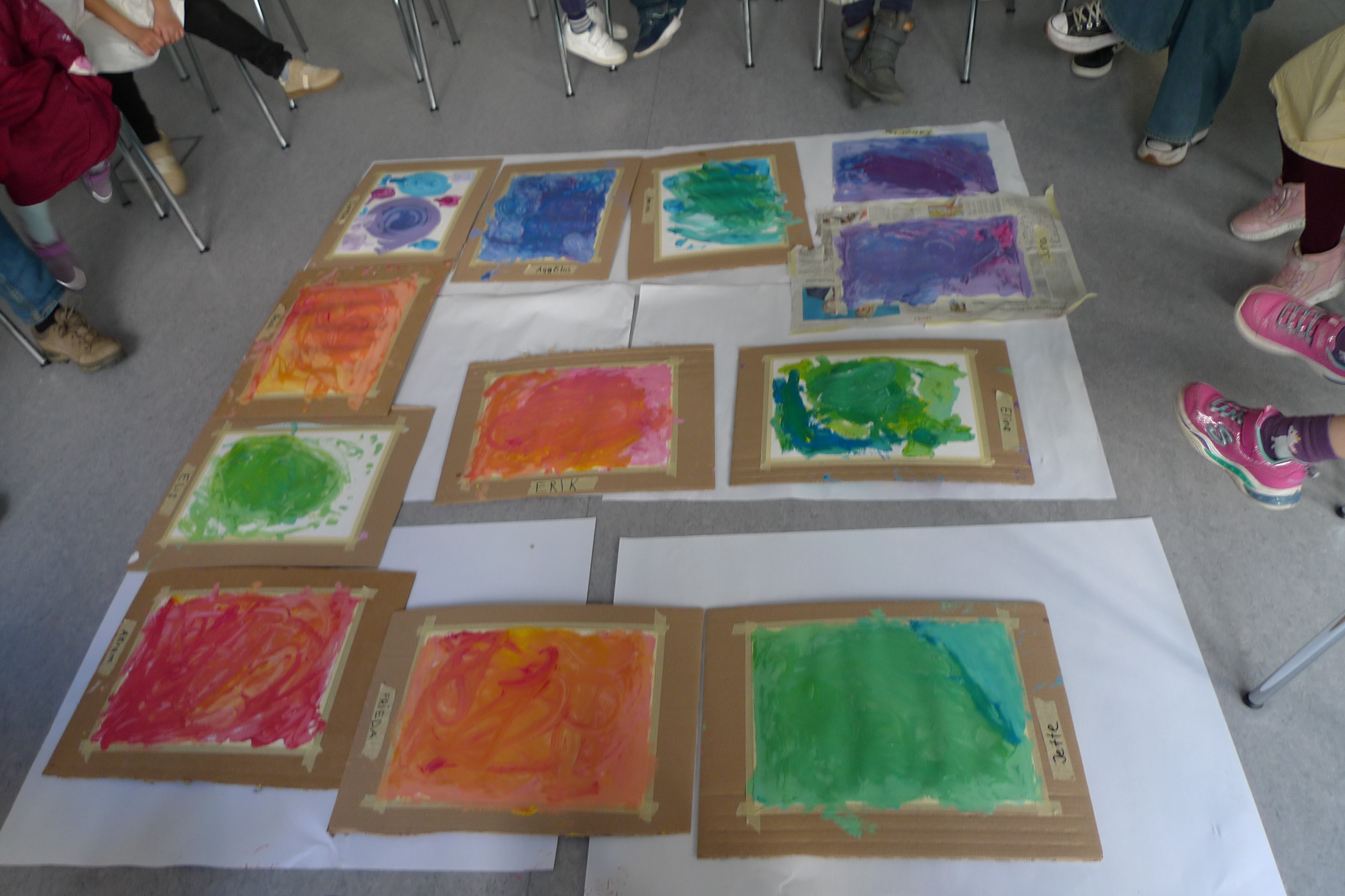 viele bunte Kinderbilder auf dem Boden, Kinderfüße