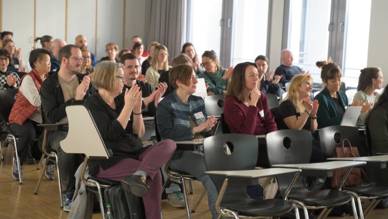 applaudierende Teilnehmende im Hörsaal