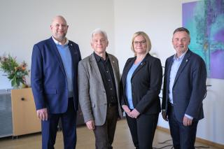 vier Personen stehe in einer Reihe in einem hellen Raum, zwei Männer, zwei Frauen - das neue Präsidium der EVHN