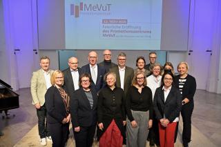 15 Personen, Männer und Frauen, stehend